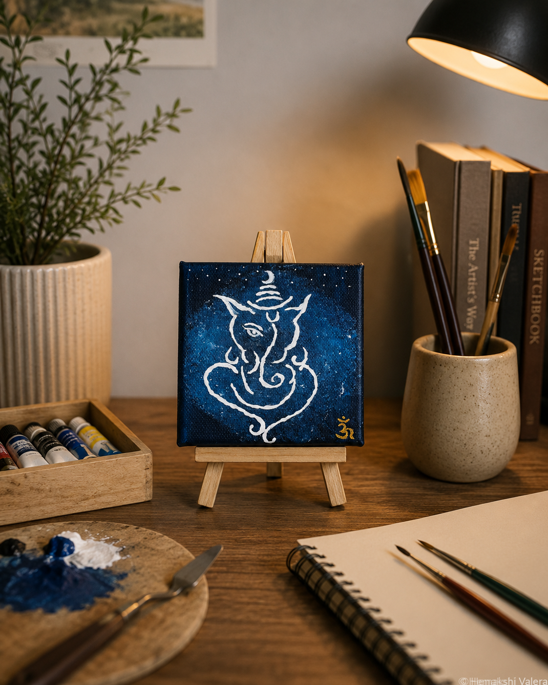By Crescent Light, an original Ganesha painting on a deep blue night sky, displayed on a shelf in a quiet corner