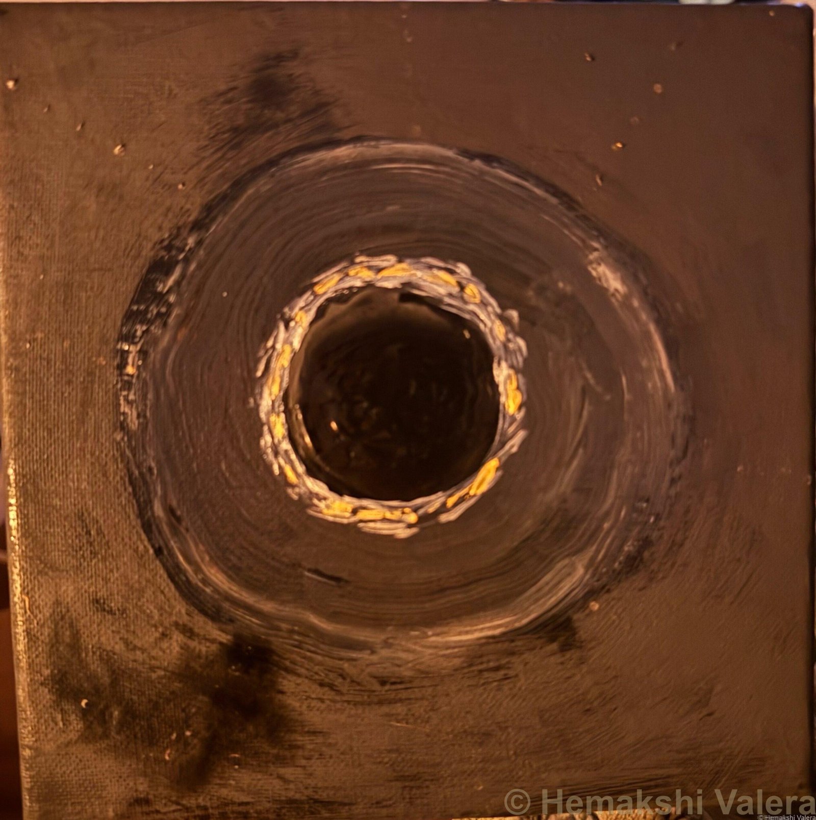 Abstract acrylic painting on black with a circular void ringed in silver and gold at the centre, by Australian artist Hemakshi Valera