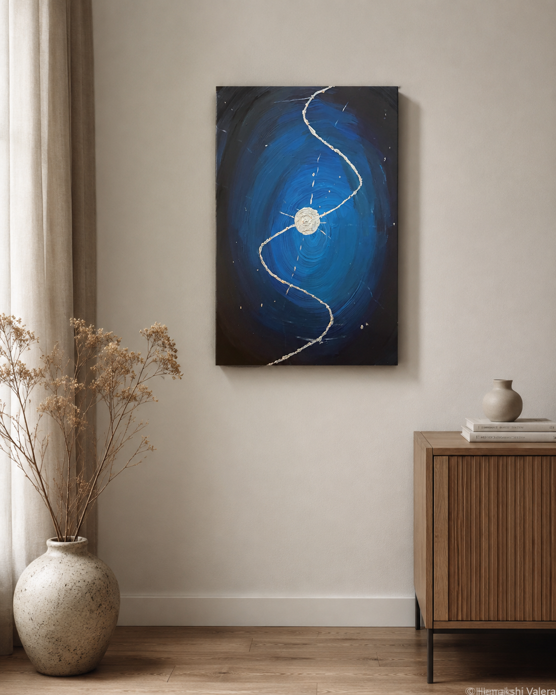 The Thread Between, an original deep blue abstract painting with a silver thread, displayed on a neutral wall above a console table